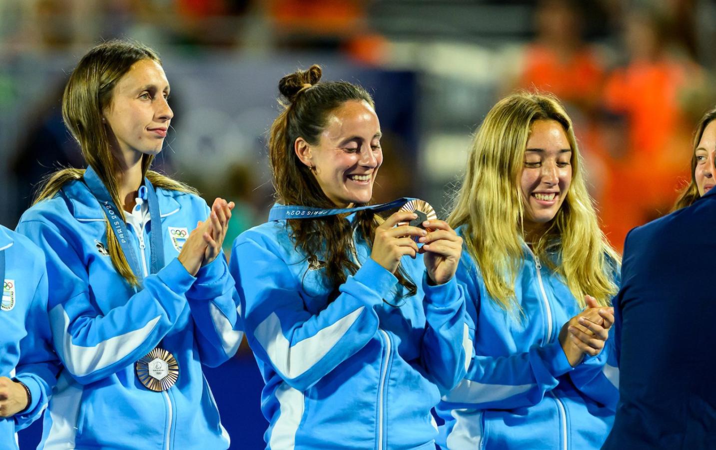Imagen Sofía Cairó, Eugenia Trinchinetti y Lara Casas aprecian la medalla. Foto: ARG FIELD HOCKEY
