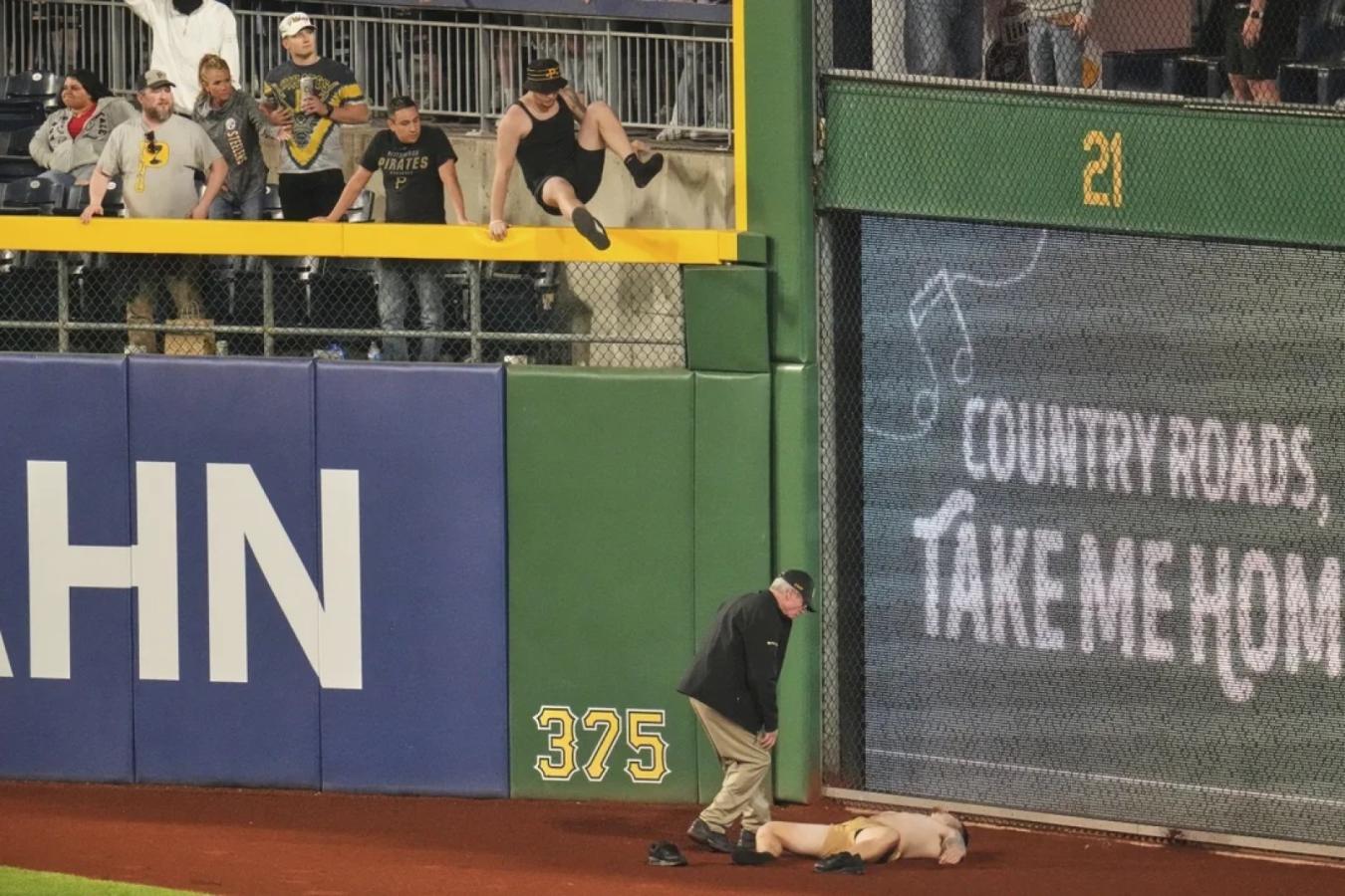 Imagen La imagen inmediata tras el accidente en Pittsburgh. Otro hincha también saltó al campo de juego para asistirlo.