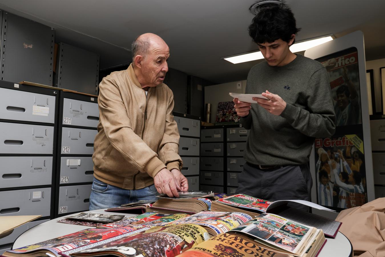 Imagen El Bocha, junto con su hijo Ricardo Simón, observando viejas fotos en el Archivo de El Gráfico.